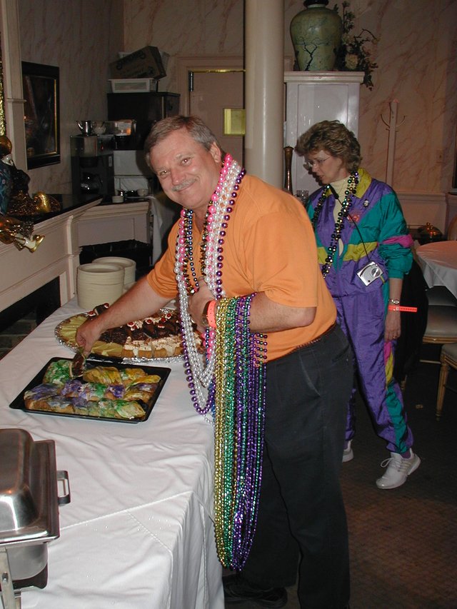 2003-02-27_18-49-33-Balcony-Jim-getting-kingcake-baby-Janeen.JPG