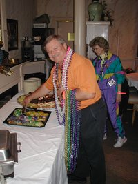2003-02-27_18-49-33-Balcony-Jim-getting-kingcake-baby-Janeen.JPG