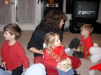 2004-12-24-Christmas-Eve-04-Suzi-reading-to-Kyla-Chance-Dax.JPG