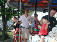 2005-04-16-Zachary-bday-Kiddie-Acres-11-Travis-Chance-Dax-merry-go-round.JPG