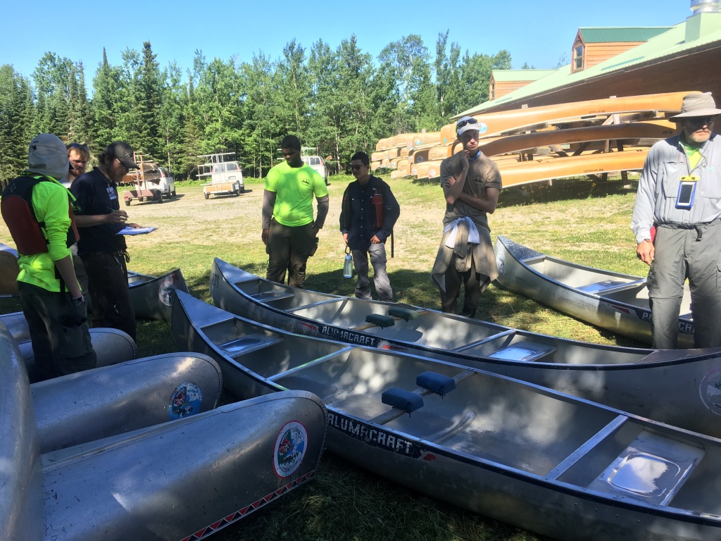 2018/06(June)/Northern-Tier-Crew-8787/1024x768_2018-06-13-Northern-Tier-Crew8787-01-Dax-Eric-Phillip-Chance-Carl-picking-canoes.JPG