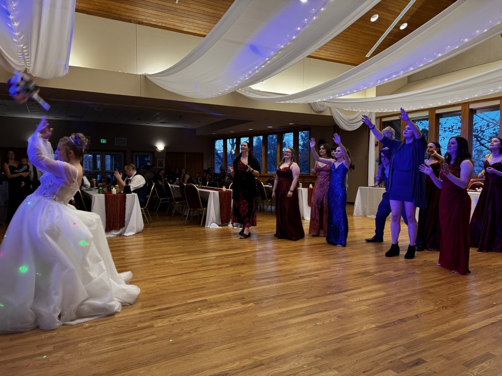 2025-11-08-McKenzie-BenBeatty-Wedding-092-boquet-toss-Zeta.JPG