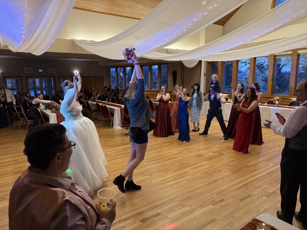 2025-11-08-McKenzie-BenBeatty-Wedding-099-boquet-toss-Zeta.JPG